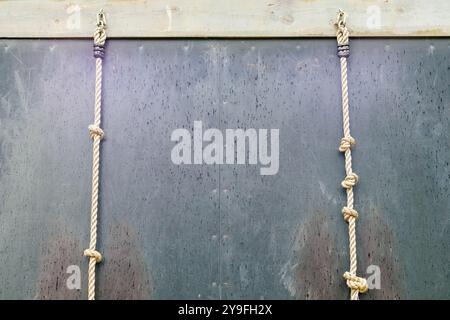 white thick rope with a knot on a brown background device in a metal hook Stock Photo