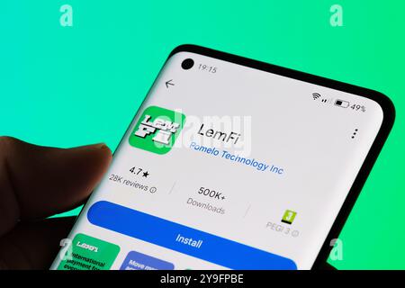 The LemFi app installation page displayed on a smartphone, highlighting its international payment features. Vivid green background. Stafford, United K Stock Photo