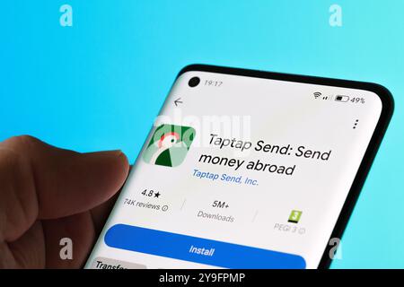 Taptap Send app displayed on a smartphone, featuring services for sending money abroad. Light blue background. Stafford, United Kingdom, October 8, 20 Stock Photo