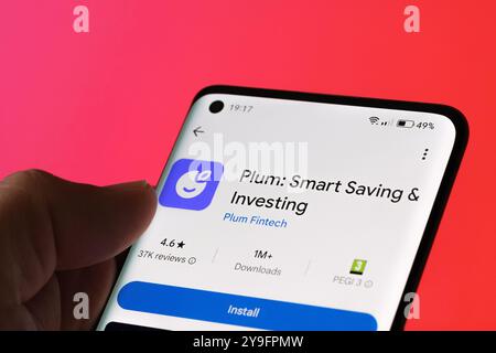 Plum app installation screen on a smartphone, highlighting smart saving and investing features. Red background. Stafford, United Kingdom, October 8, 2 Stock Photo