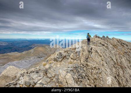 Hikers ascending the peak of the Mesa de los Tres Reyes, Hiru Errege Mahaia, 2442 meters, Western Valleys Natural Park, Huesca, Pyrenees mountain range, Spain, Europe. Stock Photo