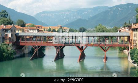 Antique wooden covered red bridge over a river, Ponte Vecchio or Ponte degli Alpini over Brenta river, Bassano del Grappa. Stock Photo