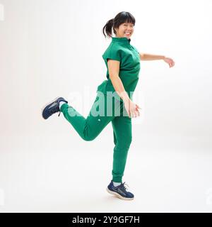 Smiling Young Doctor Running Scrubs White Backdrop Fun Happy Ponytail Stock Photo