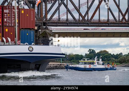 Cargo ship, loaded with containers, on the Rhine near Duisburg, boat of the water police, WSP8, Rhine bridges, Duisburg-Beeckerwerth, NRW, Germany, Stock Photo