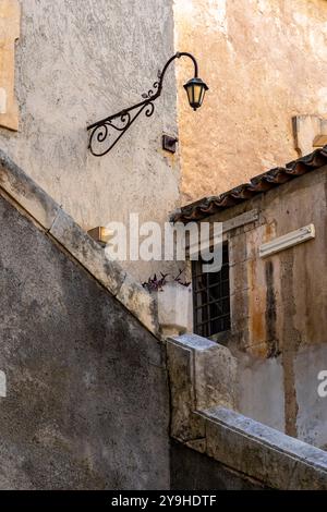 old lamp on a stone wall, above the steps, old town, Sicily Stock Photo