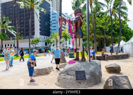 HONOLULU, UNITED STATES - Aug. 20, 2023: Tourists admiring the 9-foot bronze statue of Duke Kahanamoku at Waikiki beach in Honolulu, Oahu, Hawaii.  Th Stock Photo