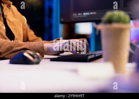 Computer technician typing lines of code on keyboard, futureproofing company network from downtimes and unexpected system failures. IT expert writing script increasing data security, close up Stock Photo