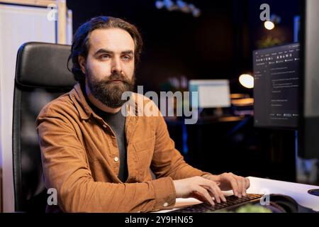 Man working cybersecurity job from home using computer to look for security vulnerabilities. IT remote employee typing on keyboard, installing safeguard code on PC to prevent cyber attacks Stock Photo