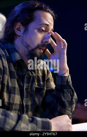 Closeup of frustrated male individual rubbing his eyes after long hours of work, having a headache. Detailed view of bearded man sitting at the table, looking tired and exhausted, feeling sick. Stock Photo