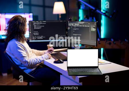Programmer using isolated screen laptop to implement security measures, protecting company systems and data. IT worker writing, testing and debugging code for software applications on mockup notebook Stock Photo