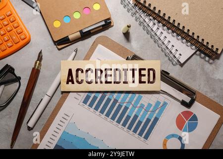 Businessman pressing his finger on the wooden cubes with the word accredited. Business industry standards concept. Stock Photo