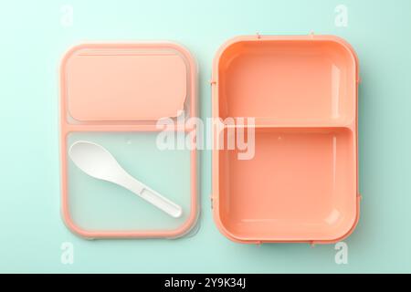 Empty lunch box with spoon on light blue background, flat lay Stock Photo