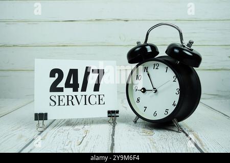 24hrs And 7 Day Service alphabet letters with alarm clock on wooden background Stock Photo