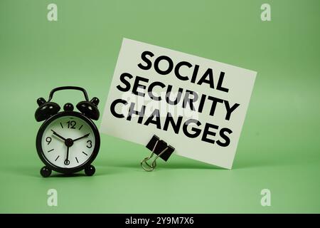 Social Security Changes text message on paper card with alarm clock on green background Stock Photo