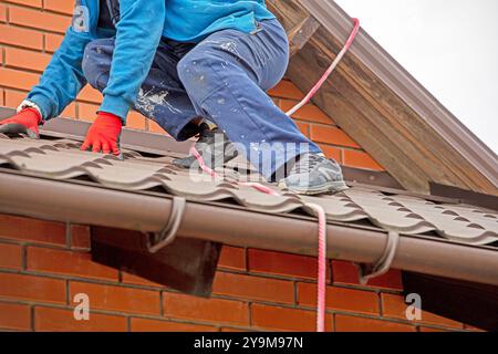 worker preparing before installing solar panels on the roof. Saving energy resources of the earth Stock Photo