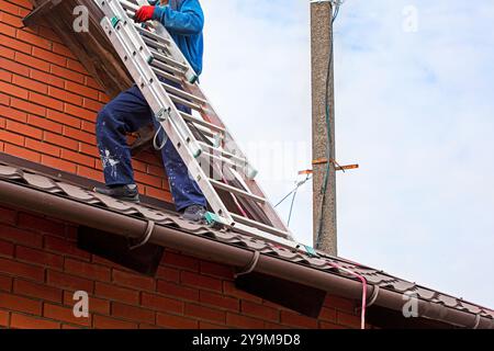 worker preparing before installing solar panels on the roof. Saving energy resources of the earth Stock Photo