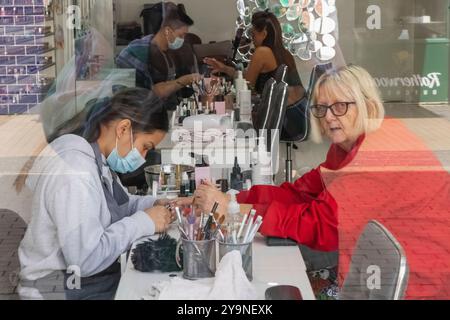 England, Kent, Dover, Street Scene, Woman in Nail Bar Stock Photo