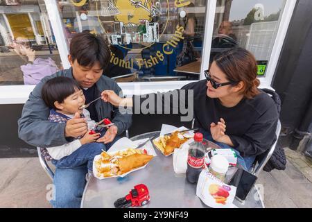 England, Kent, Dover, Asian Family Eating Fish and Chips Stock Photo