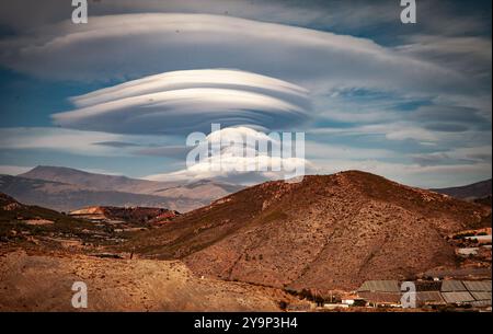 Lenticular UFO clouds above mountain range in  Sierra Nevada, Granada, Spain Stock Photo