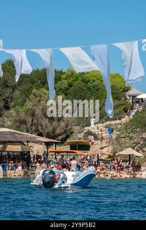 Crowded beach on Cameo island off of Laganas bay on the Greek island of Zante or Zakynthos with small hire or rental boat in the foreground. Stock Photo