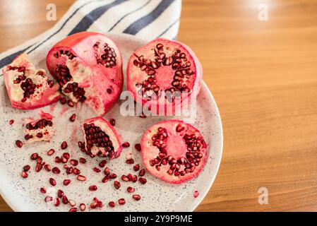 Opened pomegranates with seeds on wood table Stock Photo