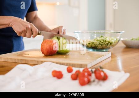 Chopping apples on a cutting board in the kitchen Stock Photo