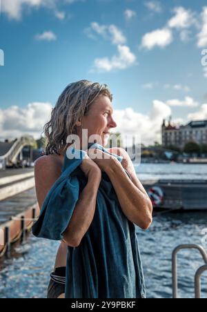 Mature Woman Looking Out At Water After Swimming Stock Photo