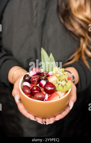 Woman holding a bowl of fruit in her hands Stock Photo