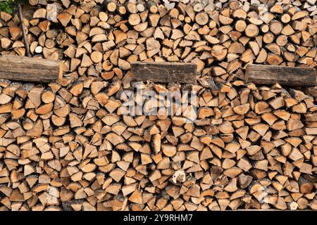 Firewood stacked in front of old wooden house in the countryside Stock Photo