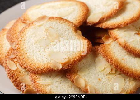 French delicacy pastry tuile with almond closeup on the plate on the table. Horizontal Stock Photo