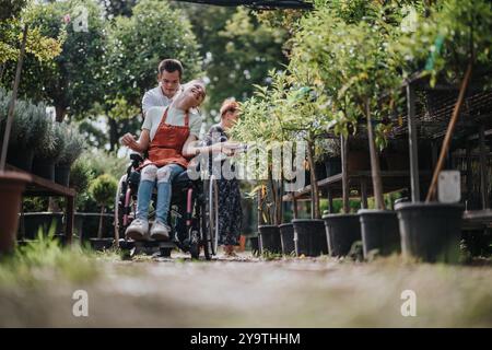 Young man with Down syndrome pushing wheelchair in garden center Stock Photo