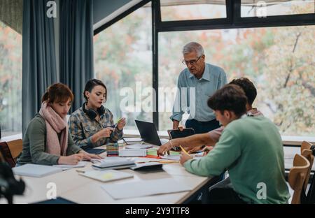 University students collaborating on a project with professor guidance Stock Photo