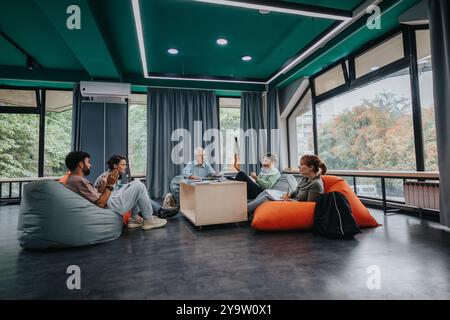 Professor engaging with students in modern study lounge Stock Photo