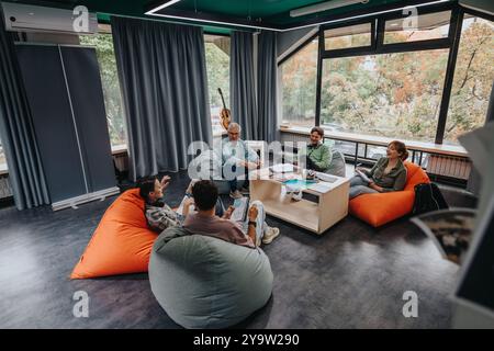 Professor engaging with students in modern study lounge Stock Photo
