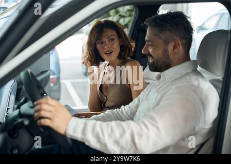 Surprised woman holding contract looking at man in new car Stock Photo