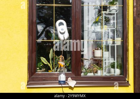 A window cleaner robot cleans windows in a house from the outside. Cleaning assistant, safe window cleaning, remote control Stock Photo