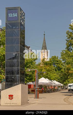 Indjija, Serbia - June 30, 2021: Modern Digital Clock Column and Mts Free WiFi Internet Station at Main Street in Town Centre Sunny Summer Day. Stock Photo