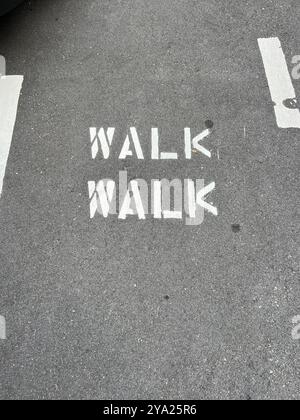 Walk walk sign on the road to remind people to walk along this stretch. Stock Photo