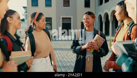 Friends, students and girls at university with talking in circle for funny conversation, college joke and backpack. Campus, people and diversity with Stock Photo
