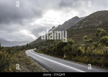 The picturesque Gordon River Rd at the Sentinel range of mountains near Bitumen Bones Sculpture on a cool wet summer's morning in Southwest National P Stock Photo