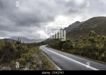 The picturesque Gordon River Rd at the Sentinel range of mountains near Bitumen Bones Sculpture on a cool wet summer's morning in Southwest National P Stock Photo