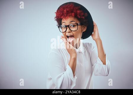 African woman, silly and surprise portrait with fashion and hipster style with wow and happy smile. Studio, glasses and trendy eyewear with minimalist Stock Photo