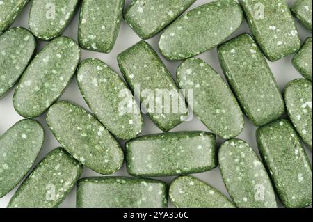 Close-up of green pills scattered on white background Stock Photo