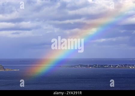 Rainbow over the Atlantic off Alesund in Norway, Norwegian Sea Colourful and cloudy sunrise over the Norwegian Sea near Alesund in Norway Stock Photo