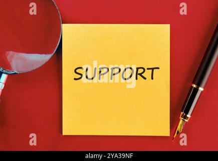 Business concept. The phrase, the text, the words SUPPORT are written on a yellow sticker on a red background. Stock Photo