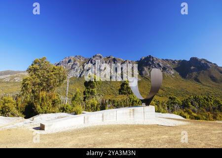 The picturesque Gordon River Rd at the Sentinel range of mountains near Bitumen Bones Sculpture on a hot summer's afternoon in Southwest National Park Stock Photo