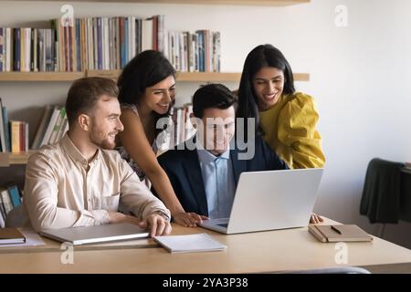 Happy diverse business team using laptop together Stock Photo
