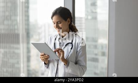 Happy young female doctor read good labs results on pad Stock Photo