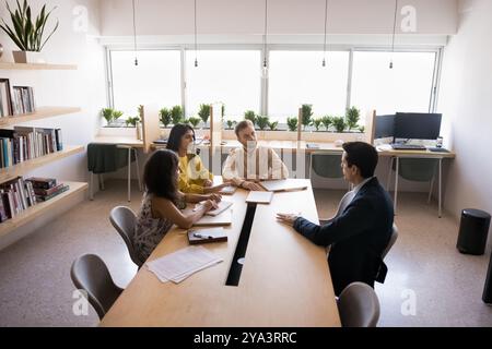 Serious engaged diverse business team talking in meeting room Stock Photo