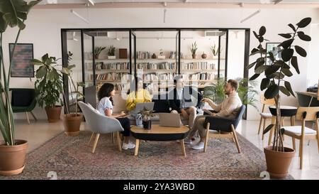 Diverse business team talking in modern co-working meeting space Stock Photo